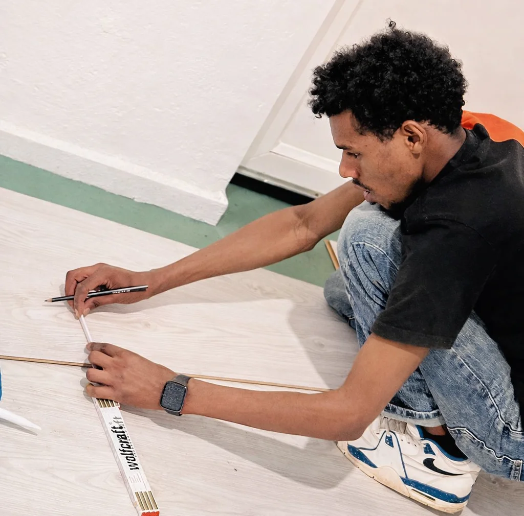 Dulazam fitter measuring laminate flooring in Greater Manchester